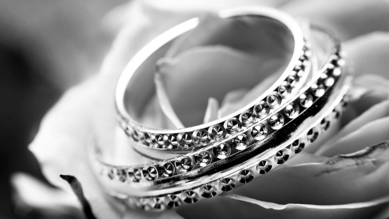 A detailed black and white image featuring ornate rings on a delicate rose, symbolizing elegance and romance., tags: mutige schmuckkollektion beim zürcher fashion - pexel