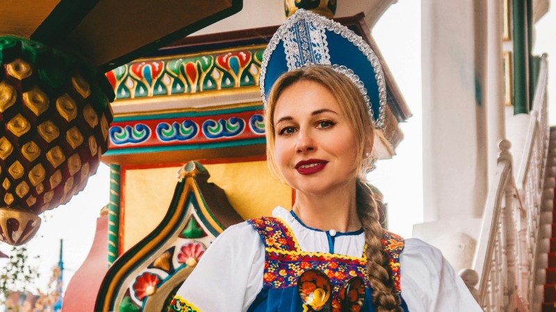 Woman in ornate Russian dress with samovar and bagels, colorful background., tags: russische - pexel